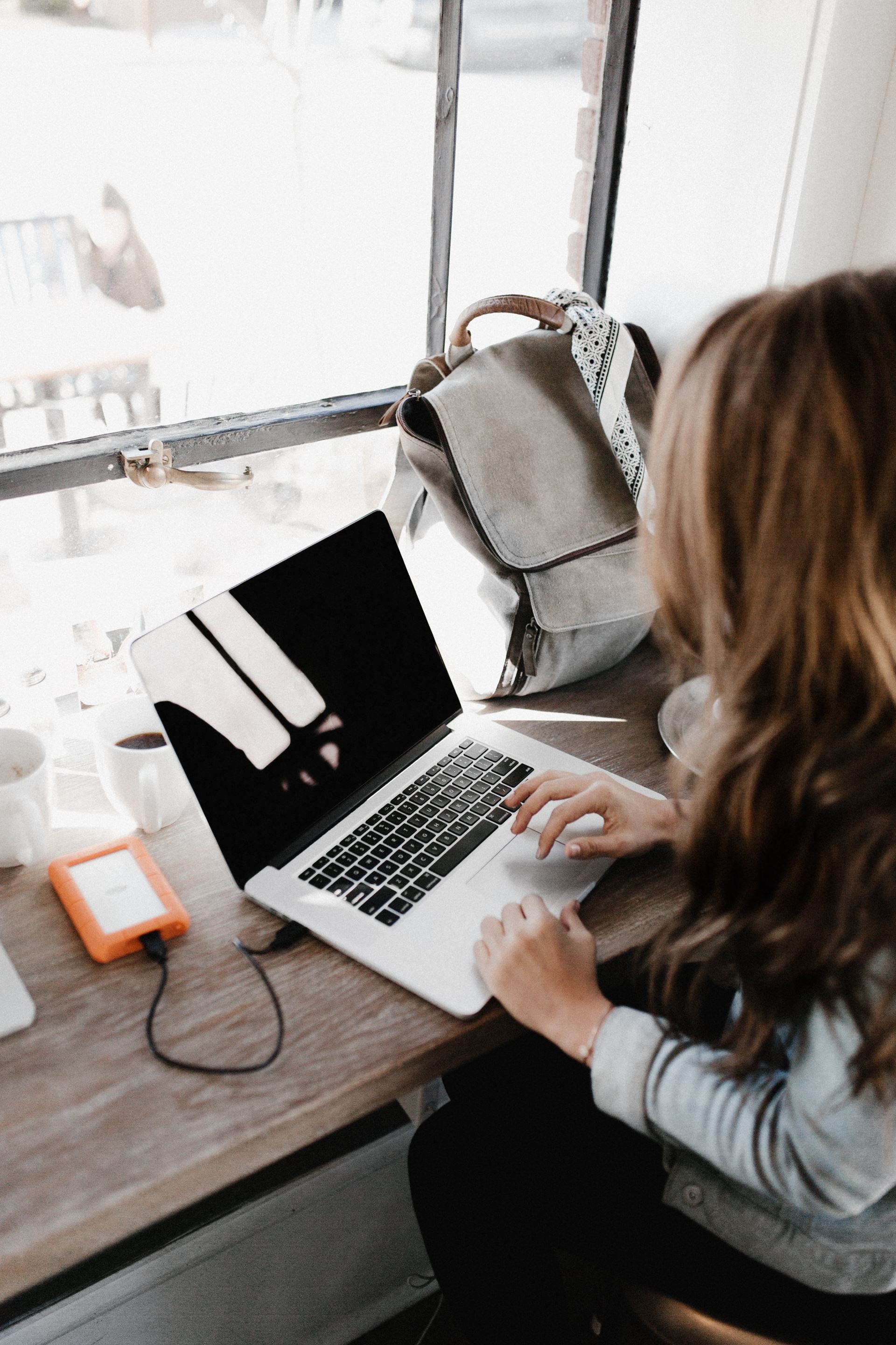 a person sitting at a table using a laptop